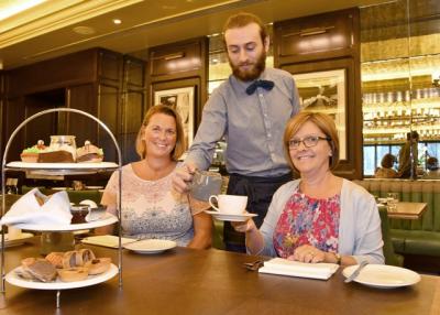 Tarnia Harrison and Julie Russell enjoy tea poured by Simon Thompson of The Grand Hotel, York